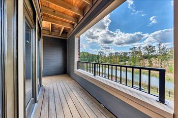 A balcony with a view of a river and trees at Luxe 360 on Centerpointe Apartments, Virginia